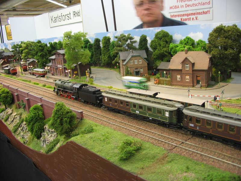 Estación de Karlsforst con un tren de época y línea de vía estrecha al fondo. También car-system